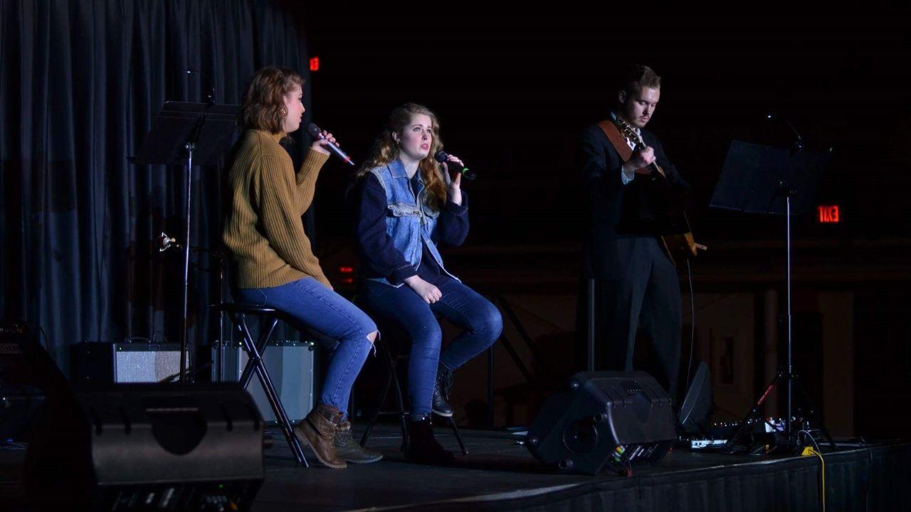 Lois singing on stage with others
